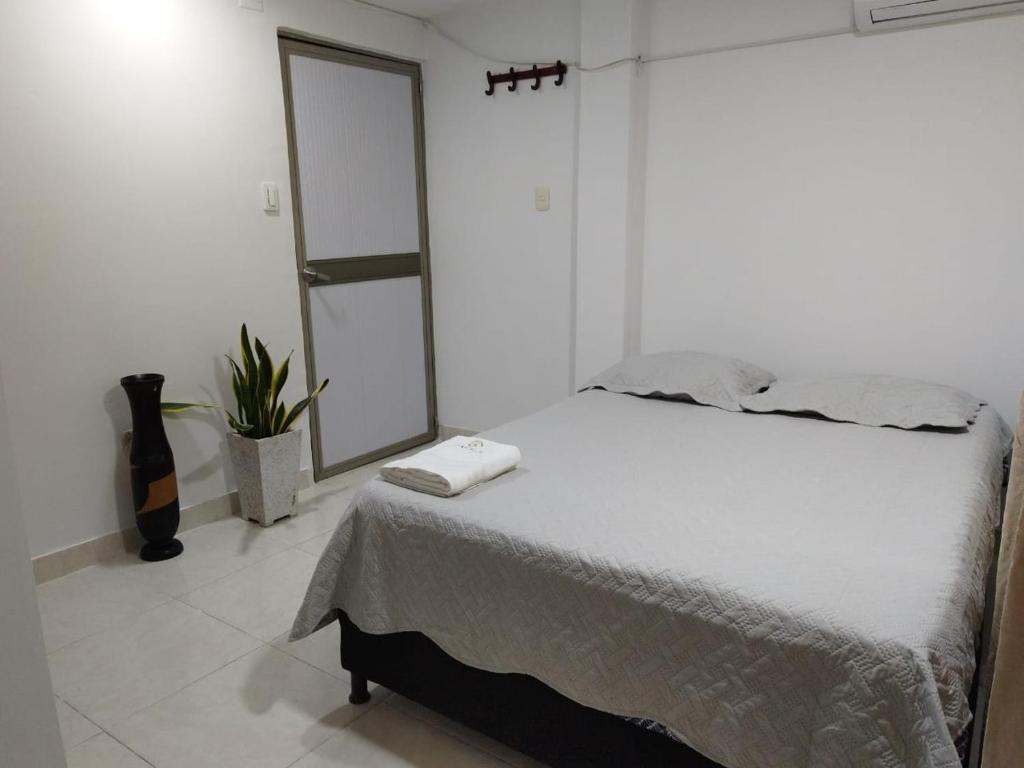 a white bedroom with a bed and a mirror at Kavala Anisa in Cartagena de Indias