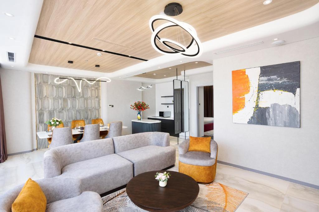 A polished living room with two sofas, an accent chair and dining area beyond.