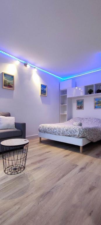 Cette chambre blanche dispose d'un lit et d'un canapé. dans l'établissement LCS home Au coeur de la ville Balcon-Parking-WIFI, à Clermont-Ferrand