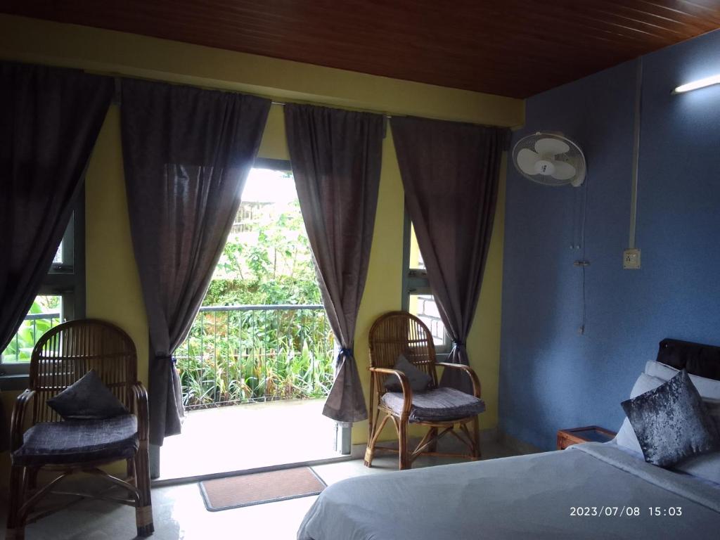 - une chambre avec un lit et une grande fenêtre dans l'établissement LaMansion Inn, à Cherrapunji