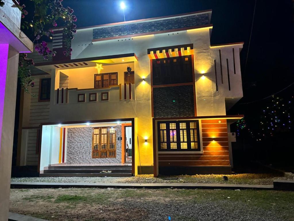 a white house with a front door at night at Bliss on the Bay in Varkala