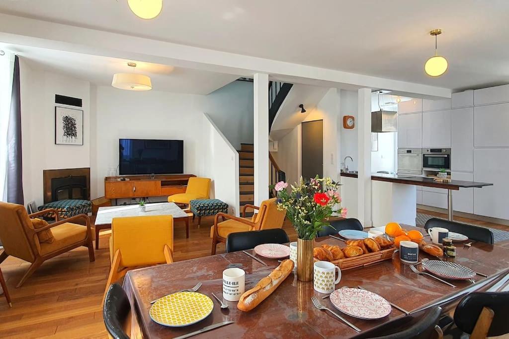 Maison de Ville Ty Art في كويبيرون: مطبخ وغرفة معيشة مع طاولة وكراسي