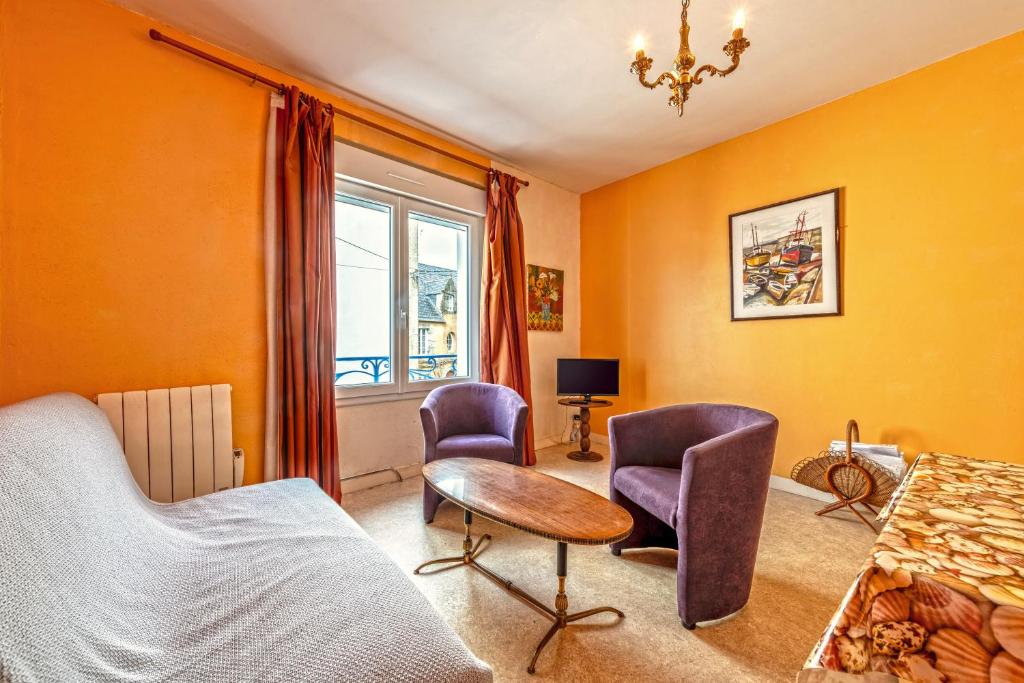 - une chambre avec des murs orange, des chaises violettes et une table dans l'établissement Maison De Ville Au Coeur De Camaret, à Camaret-sur-Mer