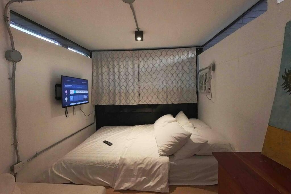uma pequena cama num quarto com uma janela em TinyHouse w/ Pool & Alfresco Area for Guests em Bacolod