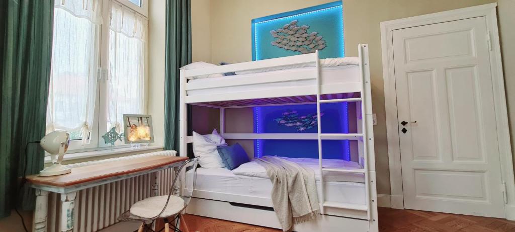 Un dormitorio con una litera con un escritorio y una ventana. en Stadtvilla Rostock - 160 qm Apartment zentrumsnah, en Rostock