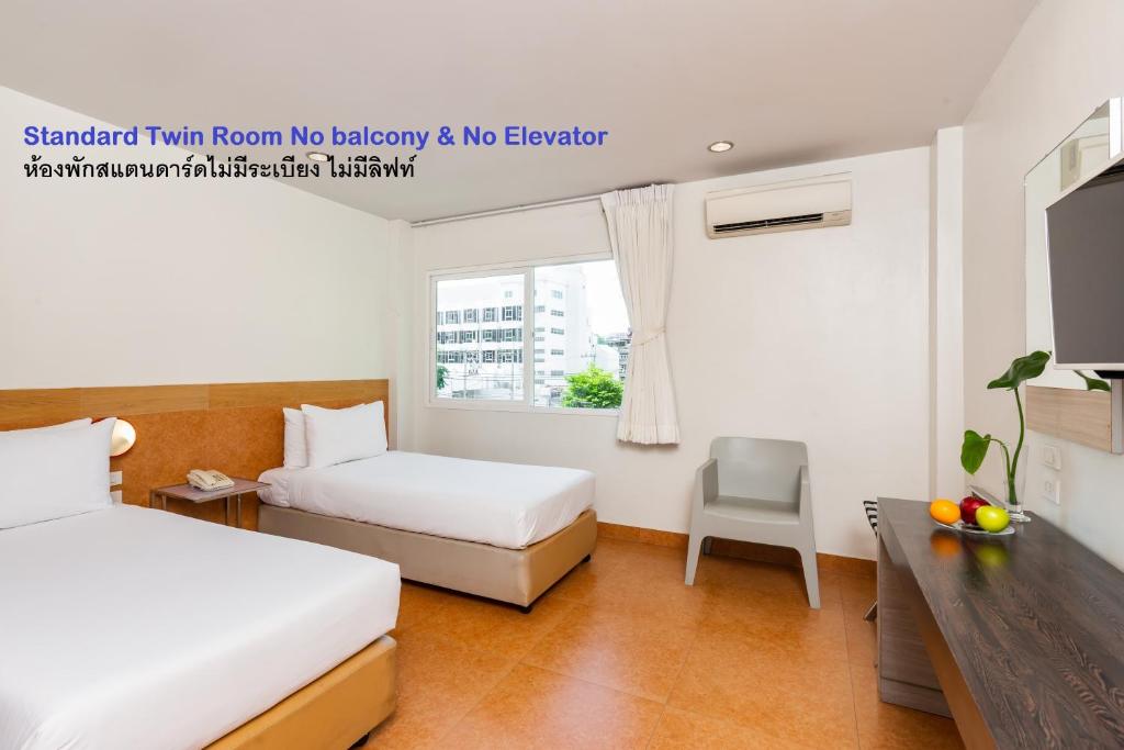 Habitación de hotel con 2 camas y TV en Grand Bella, en Pattaya central