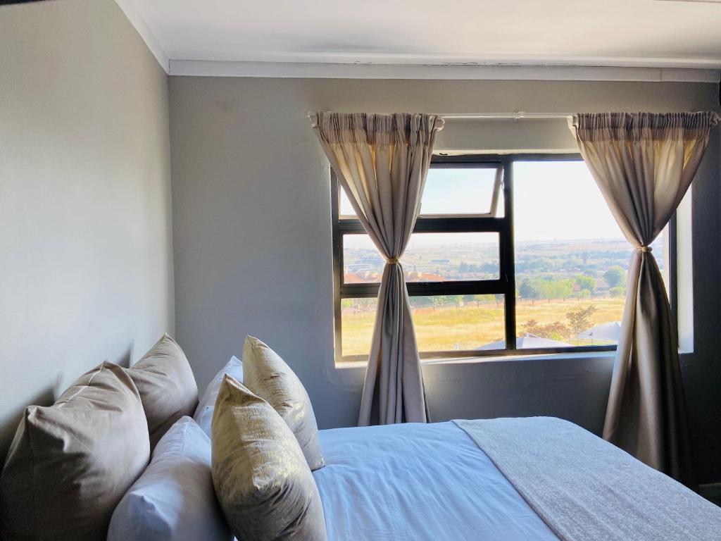 a bedroom with a bed and a large window at Gwendol’s place @ThePaddocks in Sandton