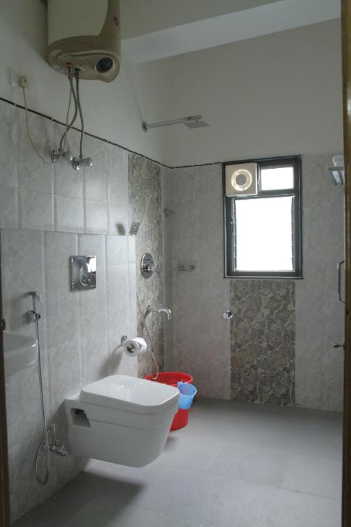 uma casa de banho com um WC e um chuveiro com uma janela em Twin Spring em Gangtok