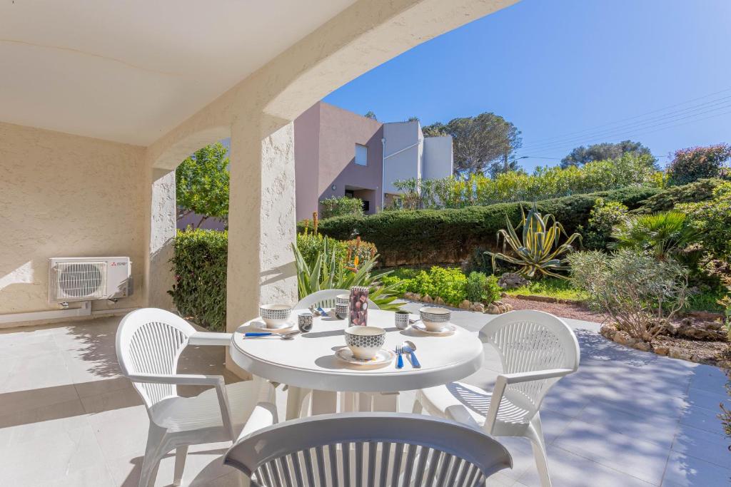 - une table et des chaises blanches sur la terrasse dans l'établissement Beau 40m² Proche du centre Wifi, à Saint-Raphaël