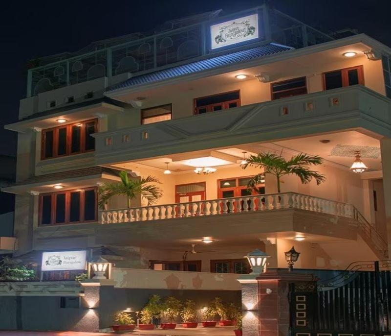 a large apartment building with a balcony at night at Jaipur Bungalow in Jaipur
