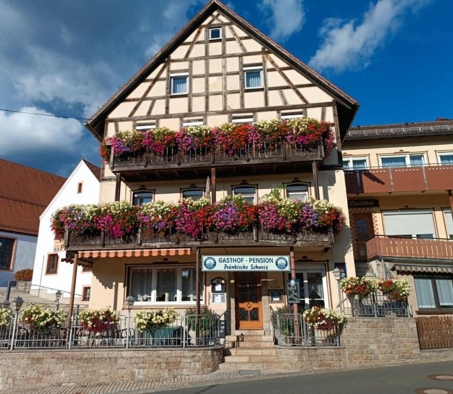 a building with flower boxes on the front of it at Gasthof-Pension Fränkische Schweiz Obertrubach in Obertrubach
