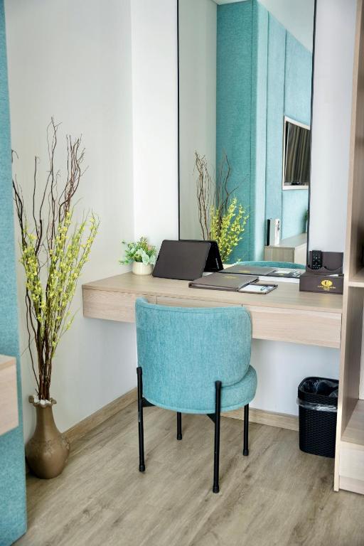 A compact in-room work desk with a blue upholstered chair.