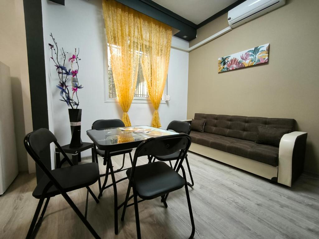 クサンティにあるPerikleous Apartmentのリビングルーム(テーブル、椅子、ソファ付)
