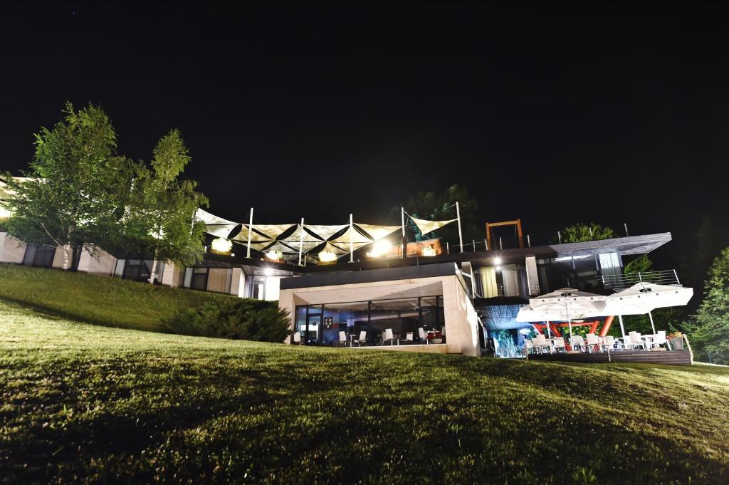 a house on a hill at night at Pensiunea Atra Doftana in Teşila