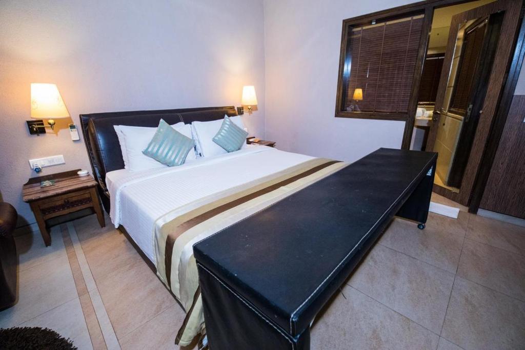 um quarto com uma cama grande e uma mesa em Hotel Le Cypress em Bareilly