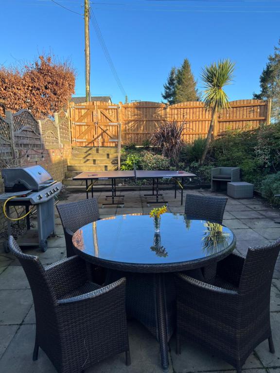 a patio with a table and chairs and a grill at The Cottage, with Superking bed & private patio in Chaddesley Corbett