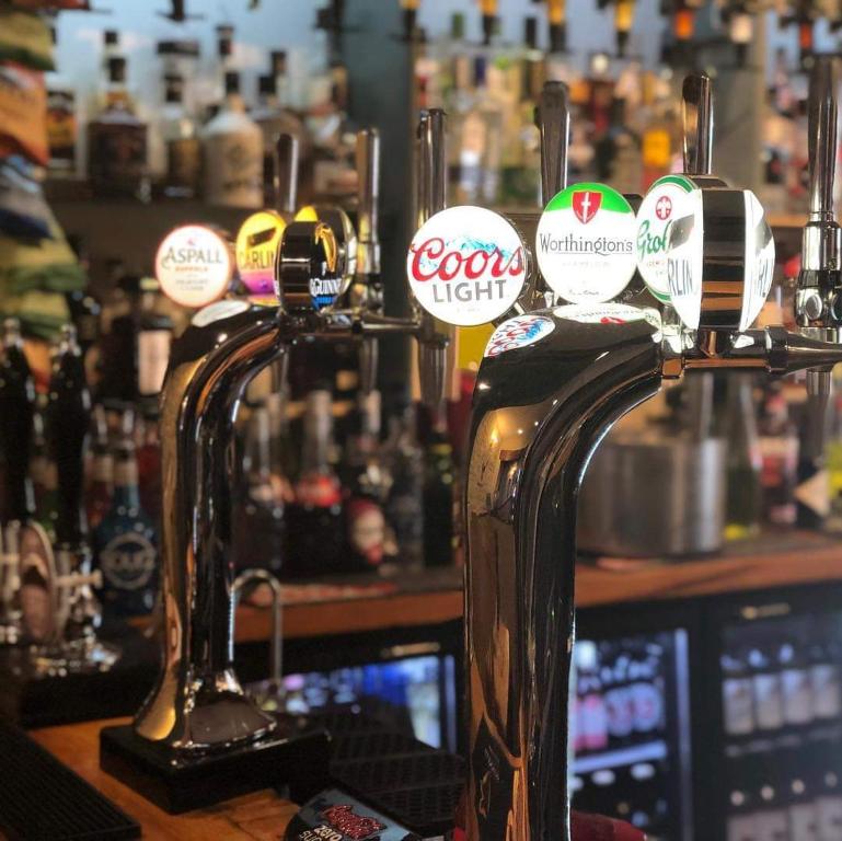 a bar with several bottles of alcohol on a counter at Nags Head Pub in Lampeter