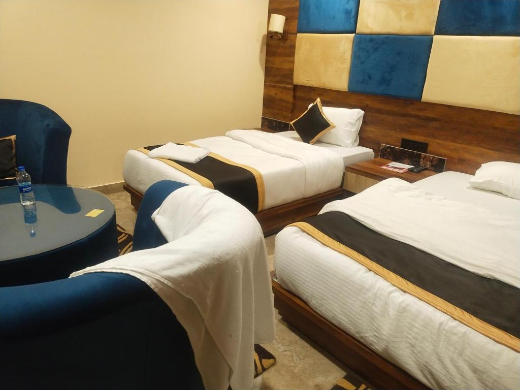 pokój hotelowy z 3 łóżkami i stołem w obiekcie Poddar Residency w mieście Kuch Bihār