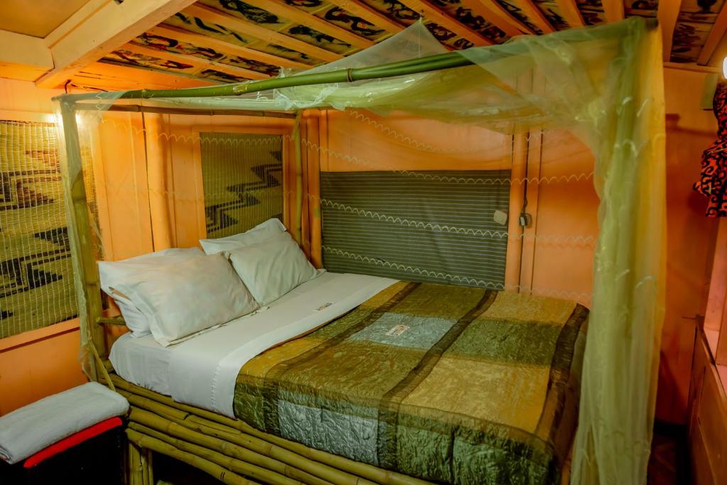 a small bed in a room with a canopy at Fravan Eco Resort By Apogee in Ruhengeri