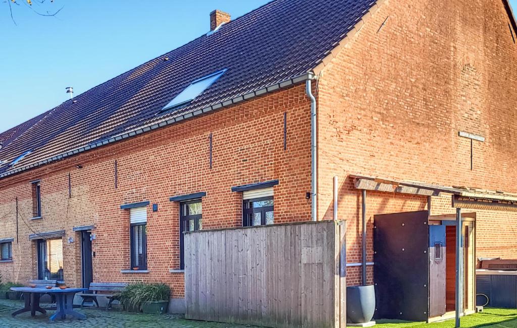 a brick building with a wooden fence in front of it at De Lindenhoeve in Sint-Katelijne-Waver
