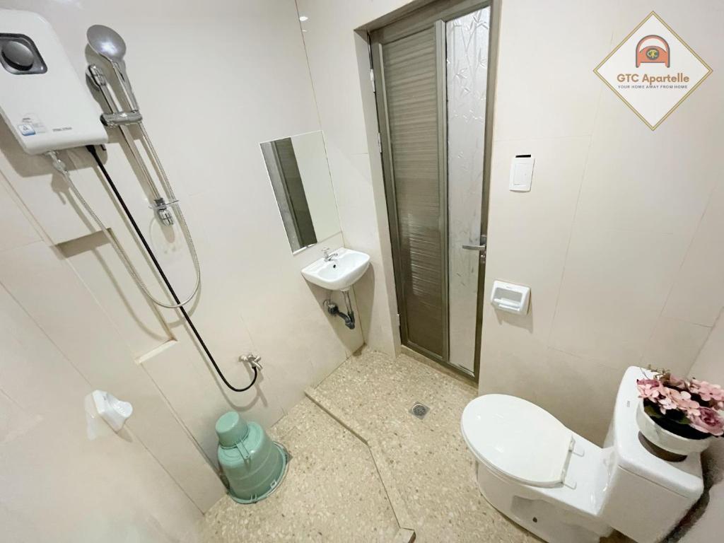 a small bathroom with a toilet and a shower at GTC Apartelle in Tacloban