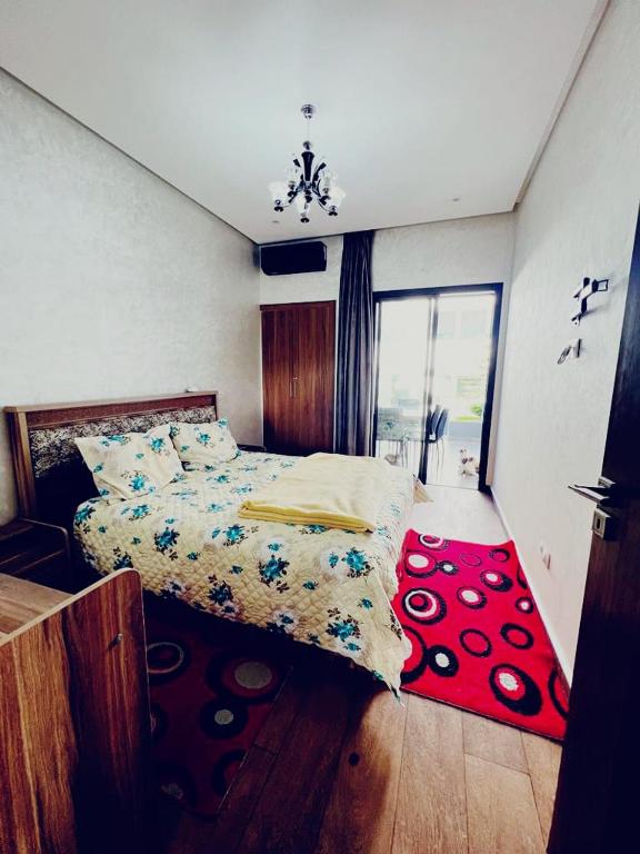 - une chambre avec un lit et un tapis rouge dans l'établissement Harhoura, à Temara