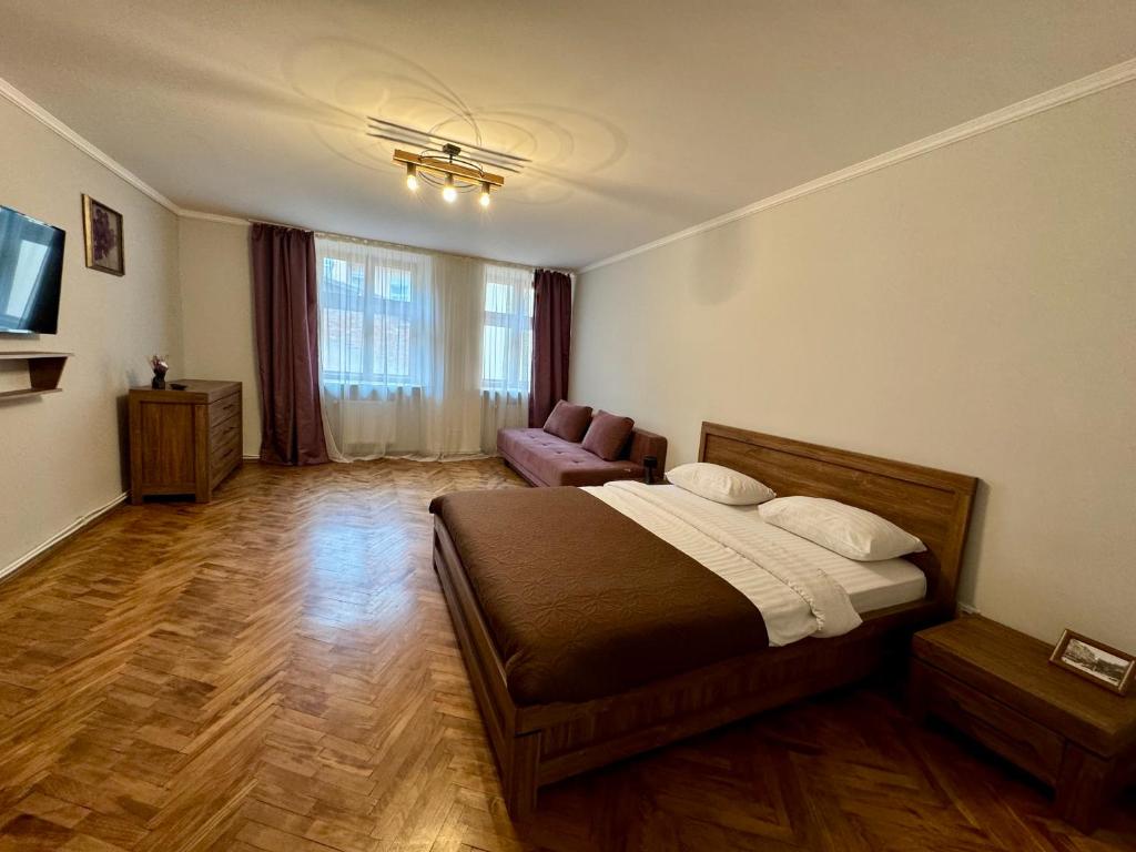 een slaapkamer met een bed en een stoel in een kamer bij Вірменська 12 in Lviv