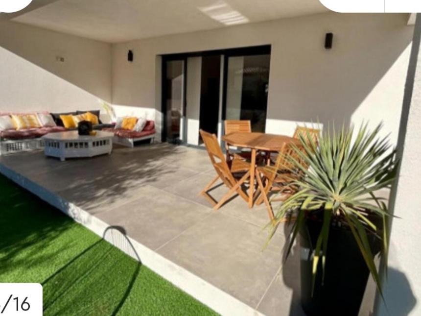 eine Terrasse mit einem Tisch, Stühlen und einem Sofa in der Unterkunft Villa au soleil in Trans-en-Provence