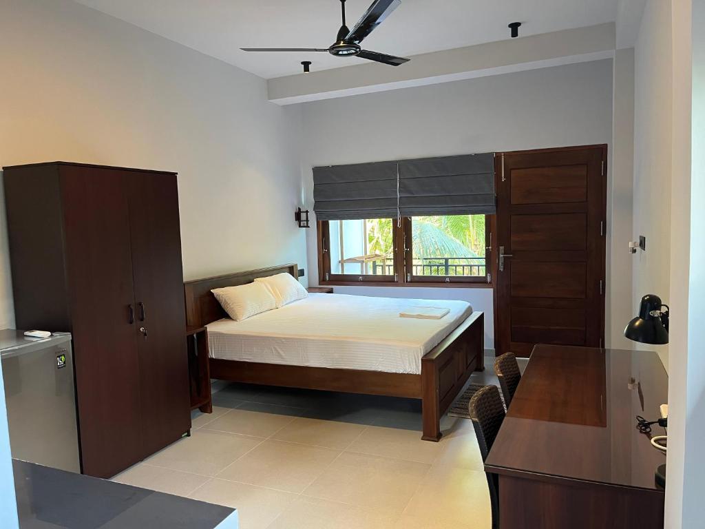 a bedroom with a bed and a window at Cozy Corner - Midigama in Midigama