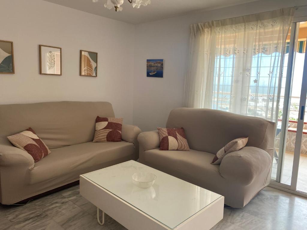 ein Wohnzimmer mit zwei Sofas und einem Couchtisch in der Unterkunft Mirador del Puerto in Aguadulce