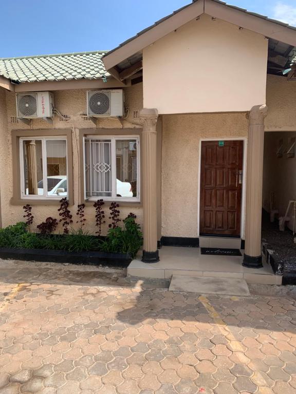 uma casa com uma porta da frente e um alpendre em JUBILEE EXECUTIVE LODGE em Lusaka