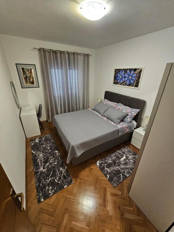 1 dormitorio con 1 cama y 2 alfombras en Apartments Grgic, en Trogir