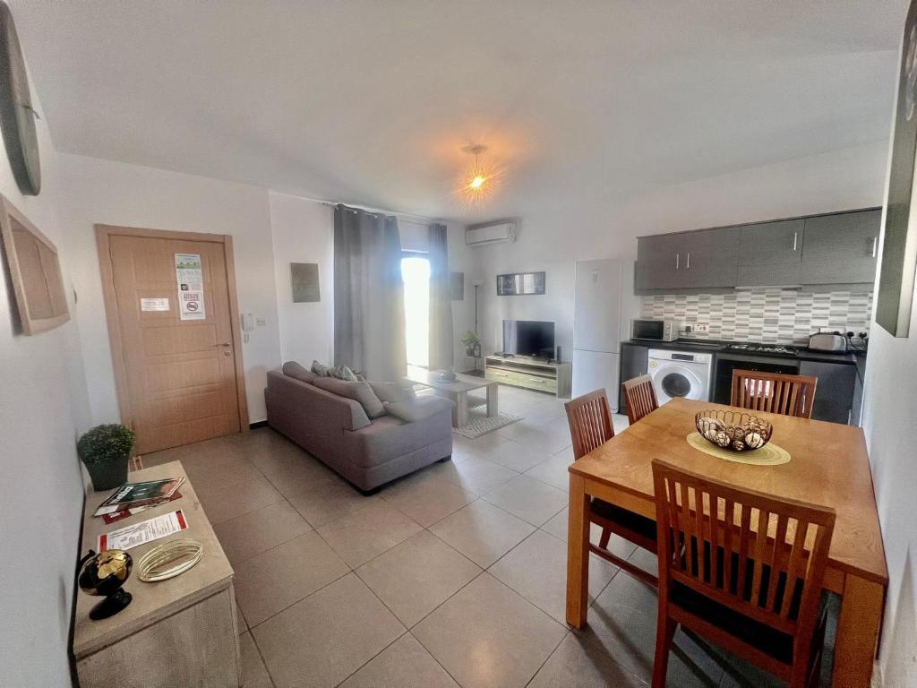 a kitchen and a living room with a table and chairs at 83/3-Lovely 1 Bedroom Penthouse in Birkirkara