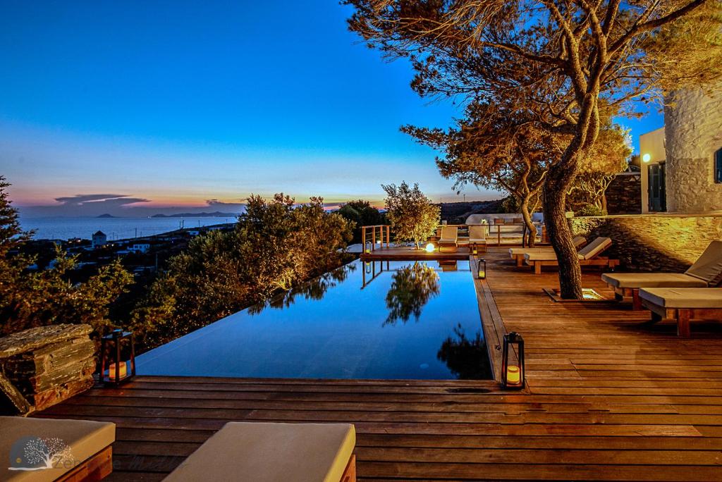 un patio trasero con piscina y terraza de madera en Zen Blue Mills, en Koundouros
