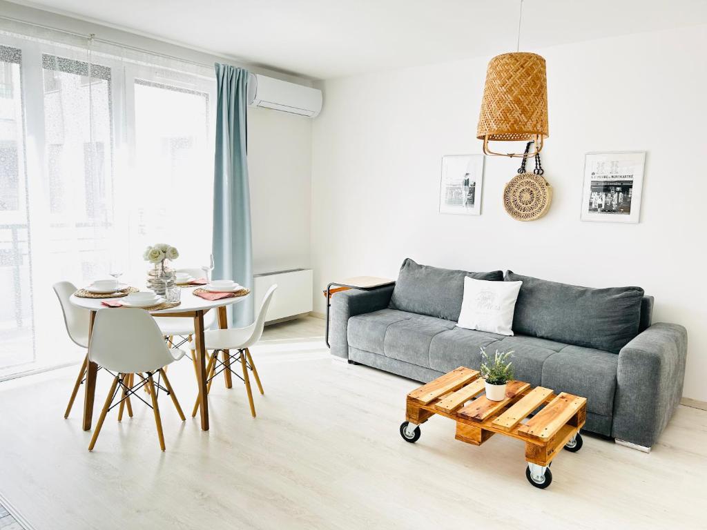 a living room with a couch and a table at Elizabeth Garden Premium Apartment in Kecskemét