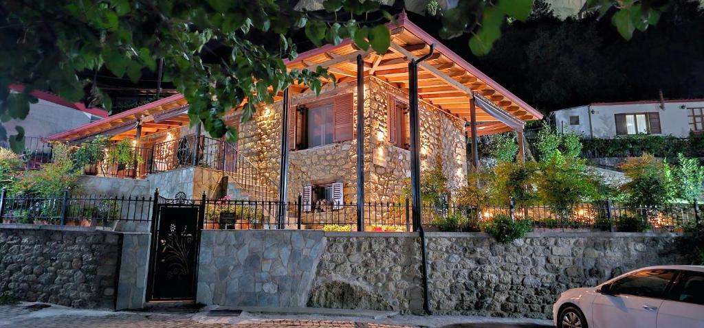 a house with a stone wall and a fence at Voulas Traditional House Meteora 3 in Kalabaka