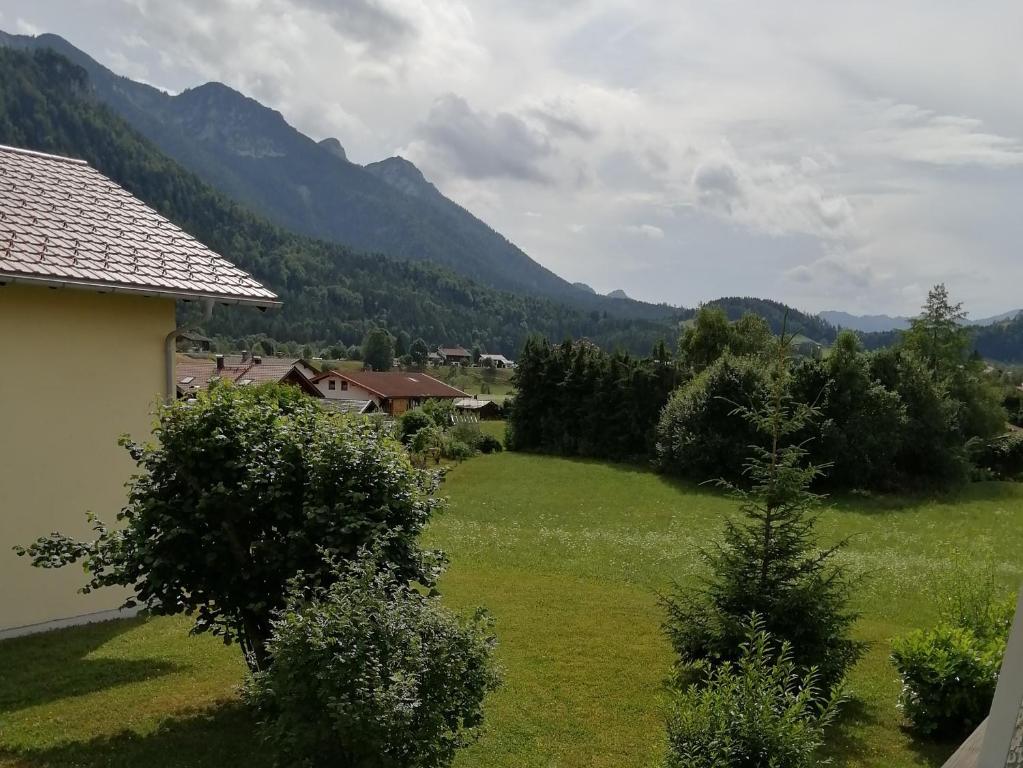 a green field with a house and mountains in the background at Ferienwohnung Gruberhörndlblick in Inzell