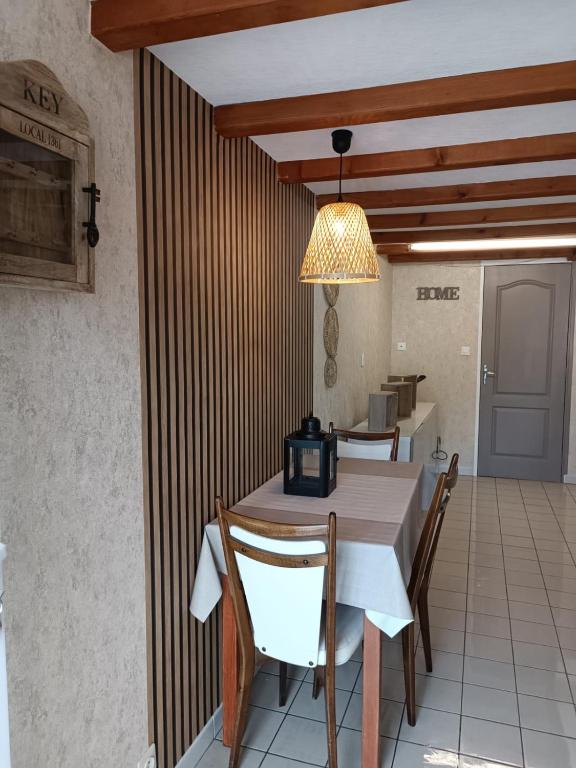 une salle à manger avec une table et quelques chaises dans l'établissement Gîte coeur de bocéliande, à Néant-sur-Yvel
