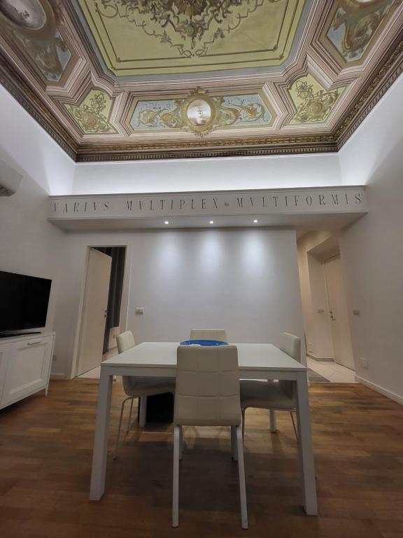 una mesa y sillas en una habitación con techo en GUVANO Luxury Apartments, en La Spezia