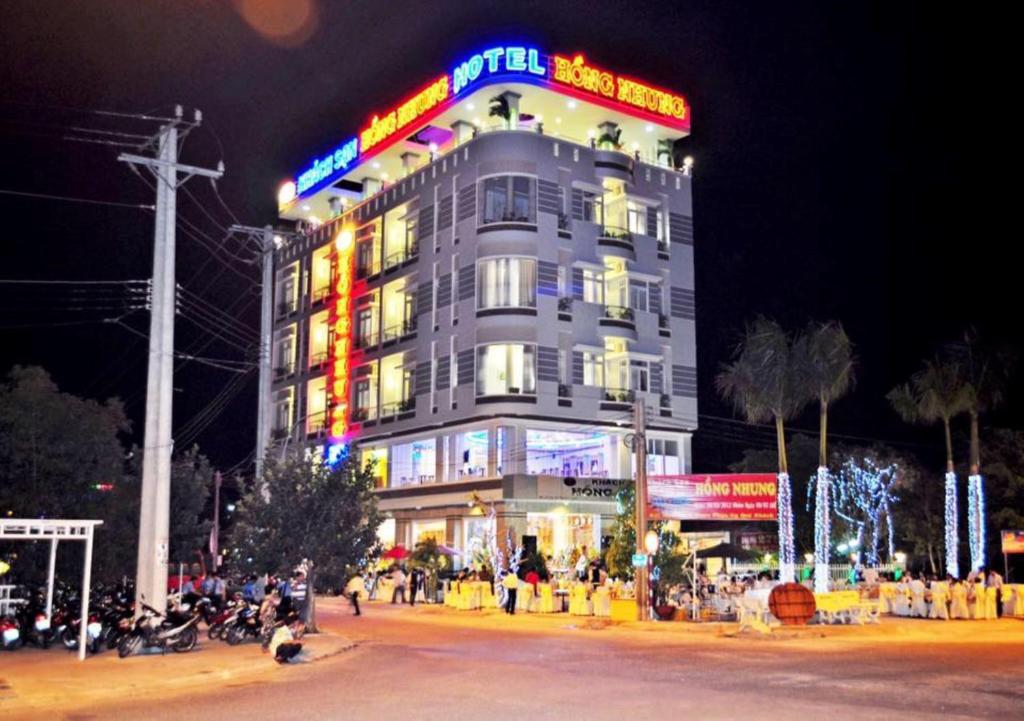 a large building with neon signs on it at night at Hồng Nhung Hotel Kiên Giang in Rach Gia