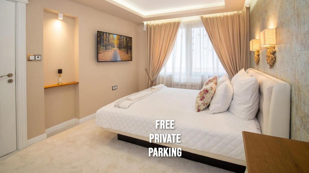 a bedroom with a white bed with a free parking sign on it at Paradise Center Premium Suite 1 in Sofia