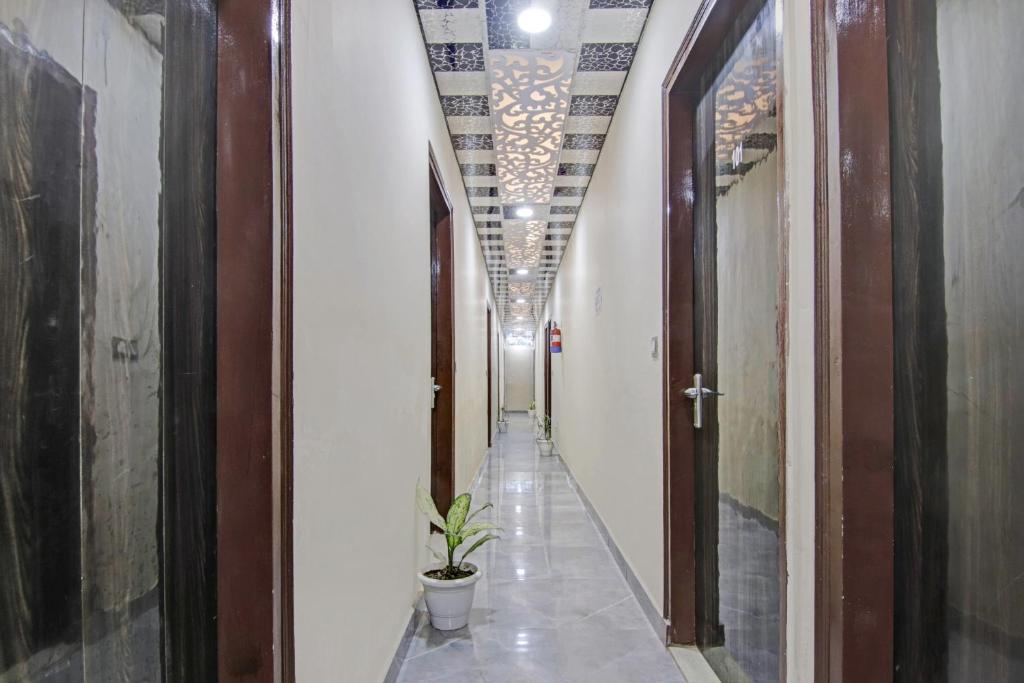 OYO Flagship 87416 Hotel Moonstar في غازي آباد: ممر فيه محطة في وسط المبنى