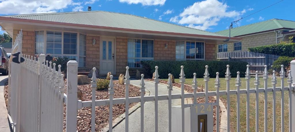 a white picket fence in front of a house at Valentine House in Hadspen