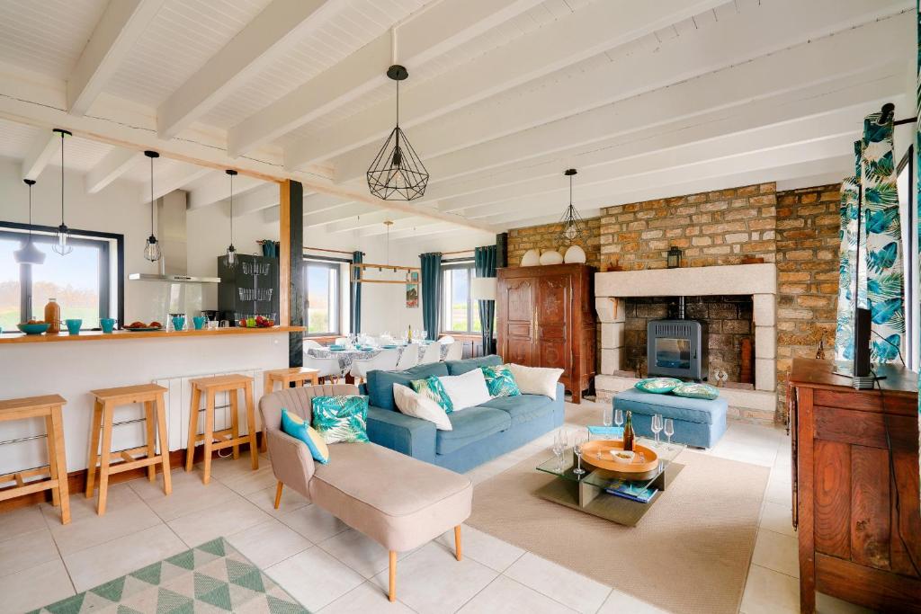 un salon avec un canapé bleu et une cheminée dans l'établissement 100m de la plage - maison pour 10 personnes, à Penmarcʼh