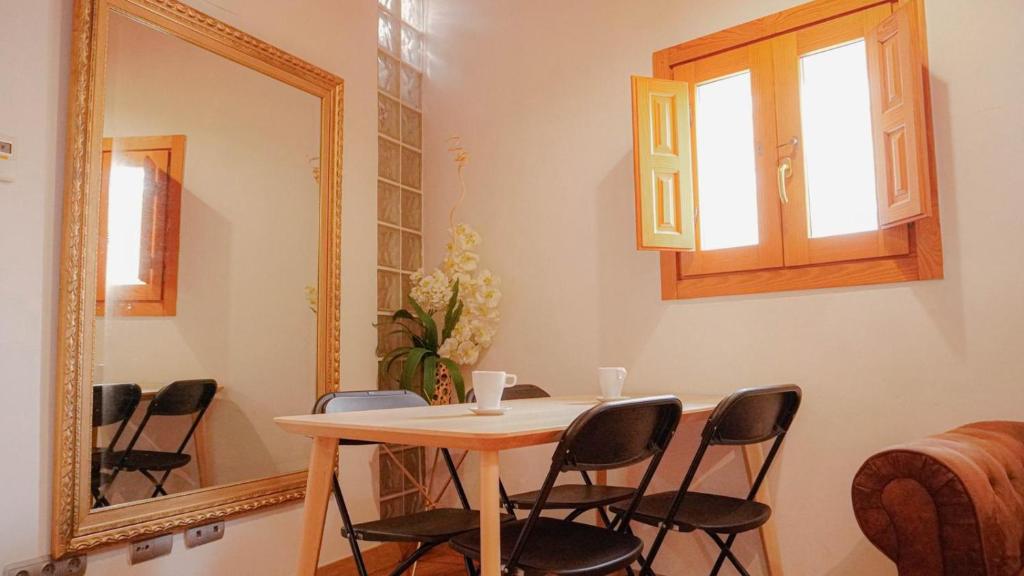 mesa y sillas en una habitación con espejo en APARTMENTS LA LONJA DE LA SEDA, en Valencia