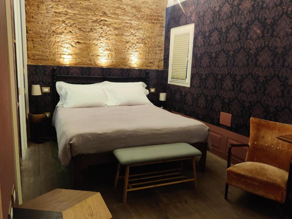 Un dormitorio con una cama grande y una silla. en Casa Sansera, en Chioggia