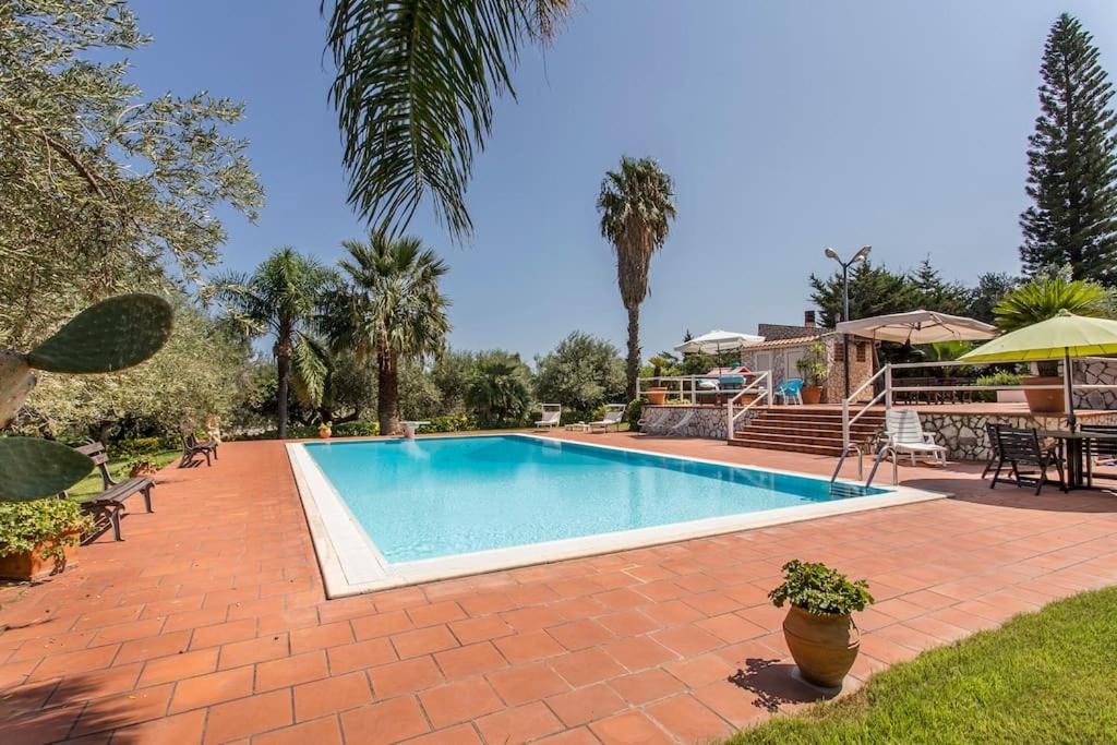 een zwembad in een tuin met een huis bij Sikelia Luxury Home in Altavilla Milicia
