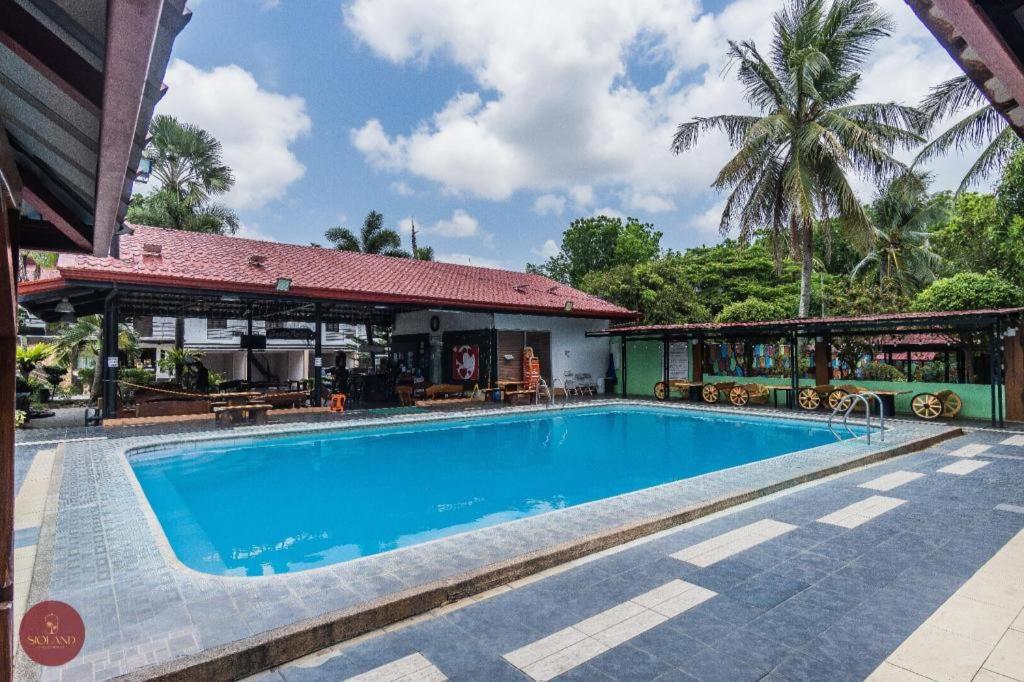 una piscina frente a un edificio con complejo en Quezon Premier Hotel Lucena, en Camp Wilhelm