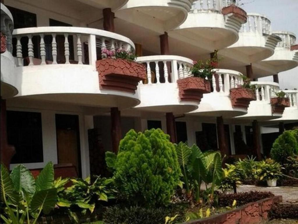 帕拉帕的住宿－Darma Agung Beach Hotel Parapat，一座带阳台的建筑,上面有盆栽植物