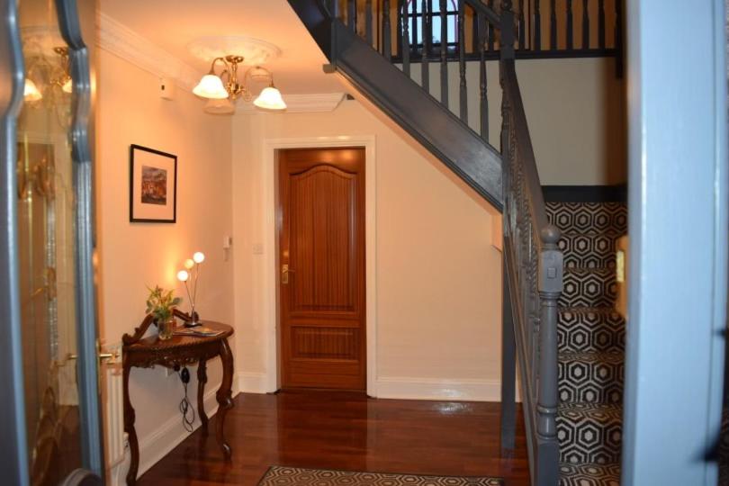 pasillo con escalera y puerta de madera en Spacious County Durham Home en Durham